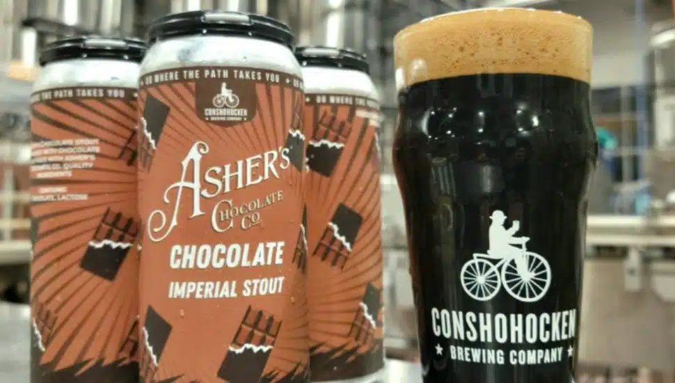 Three cans of Asher's Chocolate Imperial Stout next to a poured pint.