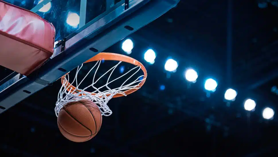 A basketball falls through a basketball hoop.