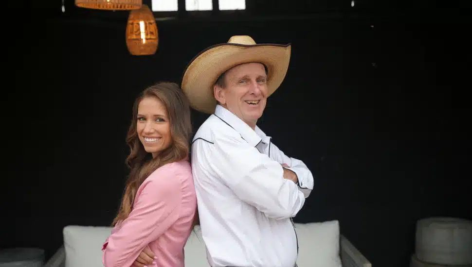 Rachel Lynn and Jeff Peiffer stand back-to-back for Flipping Farms.