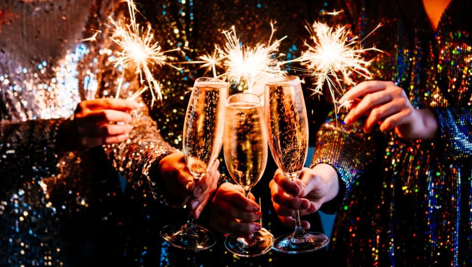 Friends celebrating New Year's Eve party with Bengal lights and champagne.