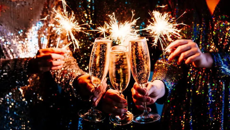 Friends celebrating New Year's Eve party with Bengal lights and champagne.
