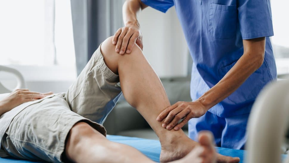 Close up of Physiotherapist working with patient on the bed in clinic