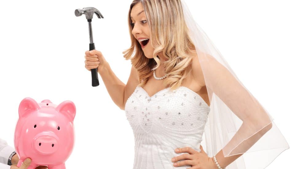 A wedding bride preparing to break a piggy bank.