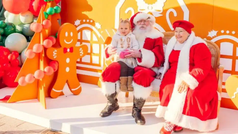 A little girl sits on Santa's lap next to Mrs. Claus at the King of Prussia Town Center Winterfest.