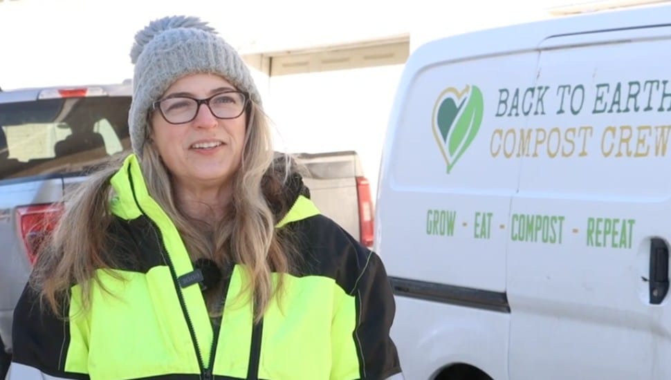 Colleen Falicki stands next to a van branded with the Back to Earth Compost logo.