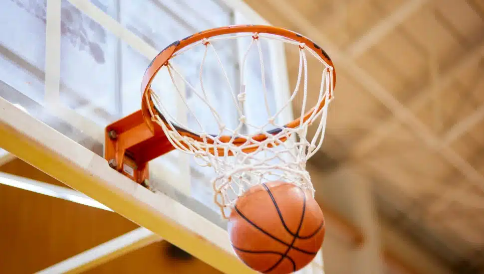 A basketball swishes through the net.