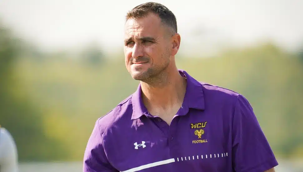 Headshot of young football coach in purple shirt.