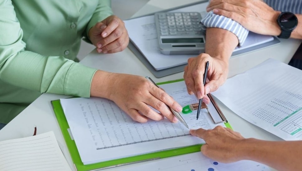 Three people do HR work at table.
