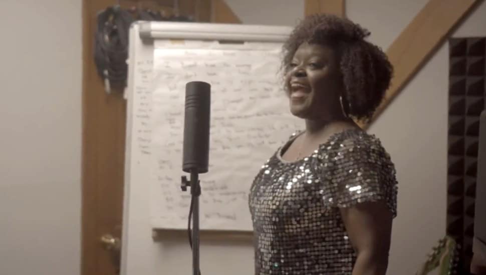 Vanessa Howard sings into a microphone.