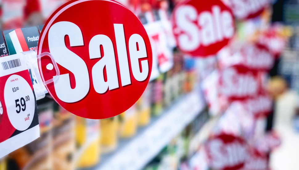 Sale signs placed on food shelves.