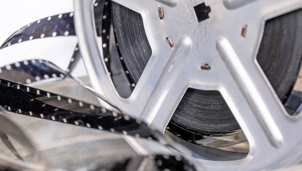 Metal reel with retro film strip sixteen millimeters close-up.