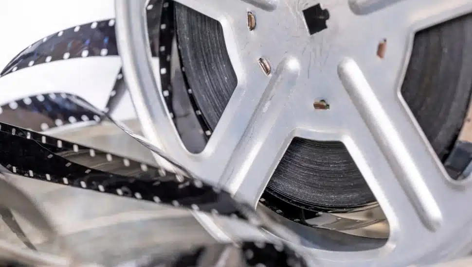 Metal reel with retro film strip sixteen millimeters close-up.