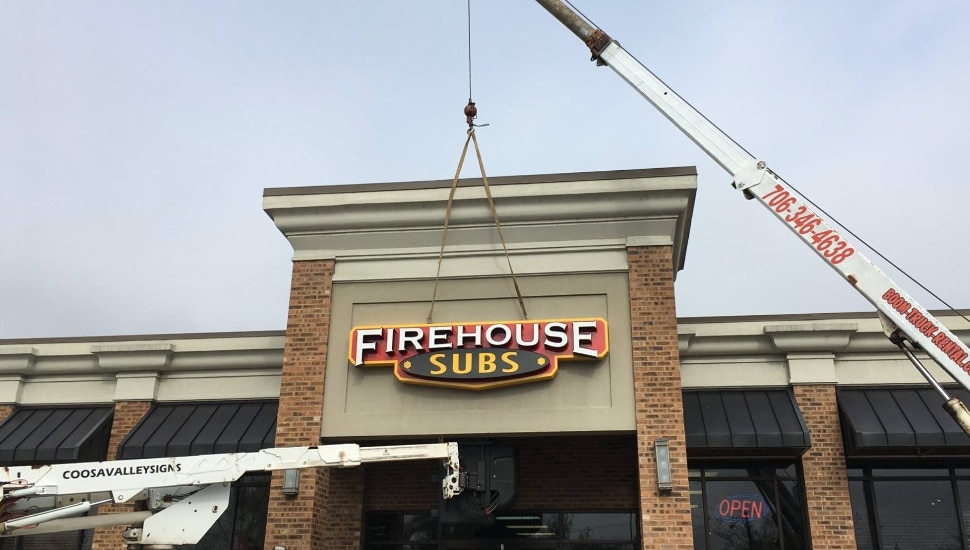 A Firehouse Subs sign erects over a new location.