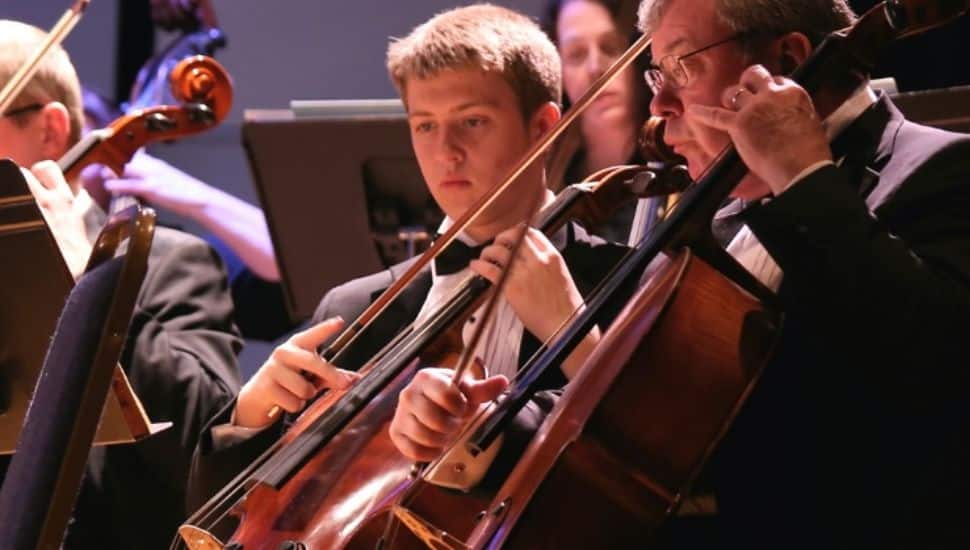 Immaculata Symphony musicians performing on stage with string instruments during a live orchestral concert at Alumnae Hall Theater.
