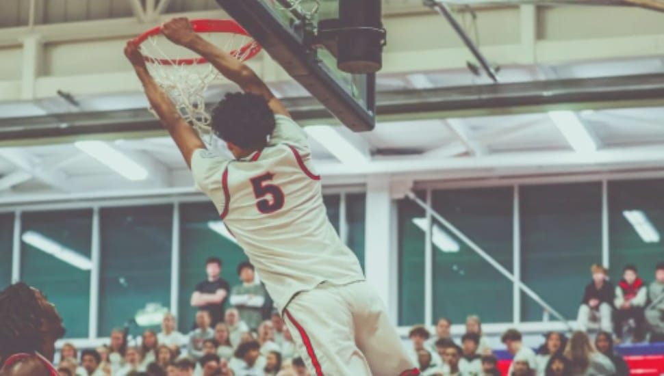 Mani Sajid dunks a basketball.