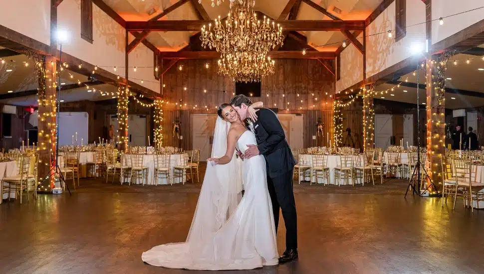 A newlywed company embrace on the dance floor at Normandy Farm.