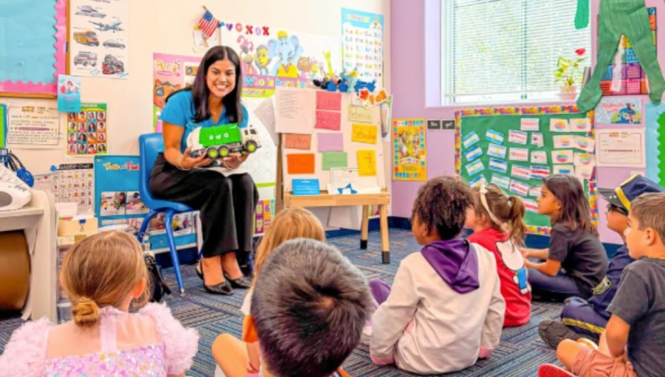 A teacher reads to small children at The Learning Experience.