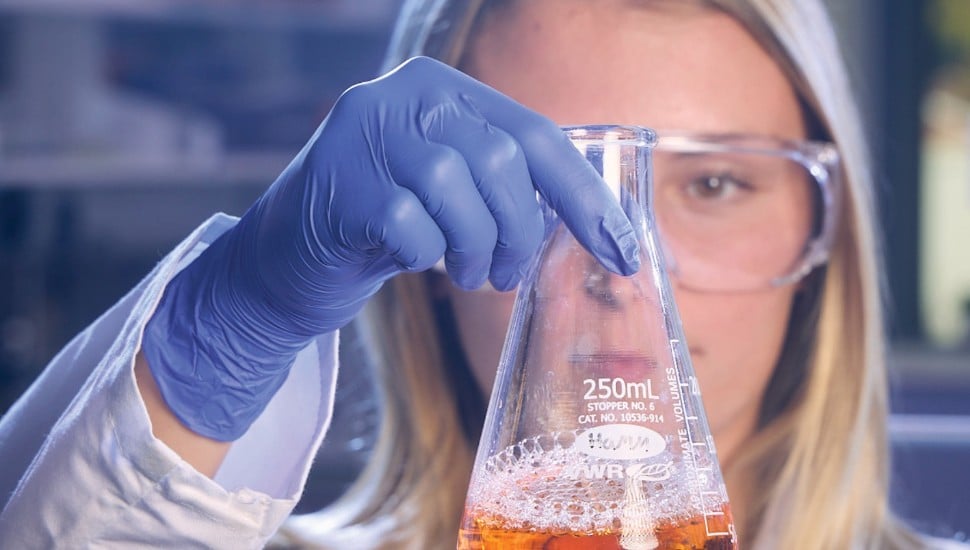 An Ursinus student observes the contents of a conical flask.