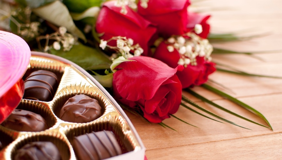 Valentine's Day roses and chocolate candy on a wooden table