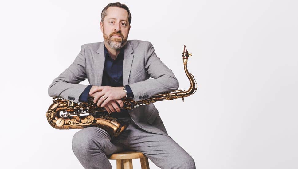 Maxfield Gast seated with a saxophone.