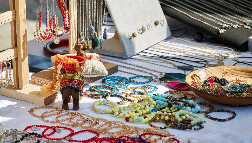 A table with handmade jewelry at a craft fair.