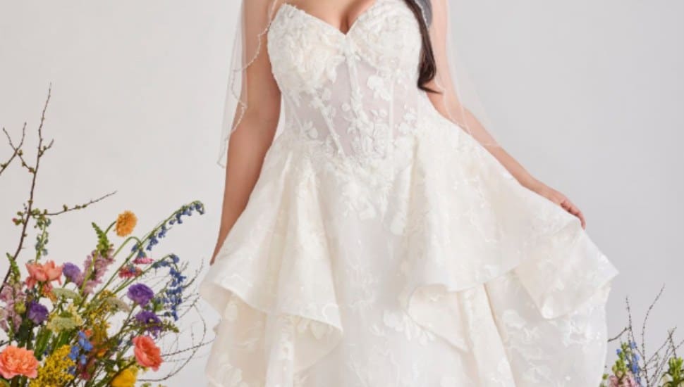 A cropped image of a bride in a wedding gown surrounded by flowers.