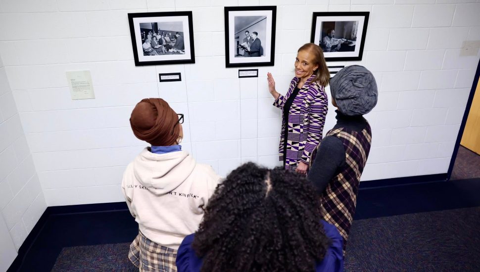 Dorothy Davis shows viewers some of Griff Davis' photos on a wall.