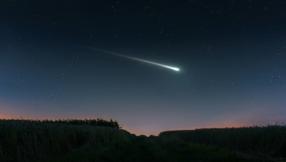 A meteorite streaks across the night sky.
