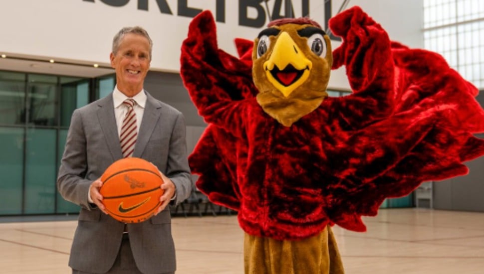 Head coach Steve Donahue stands with St. Joe's Hawk.