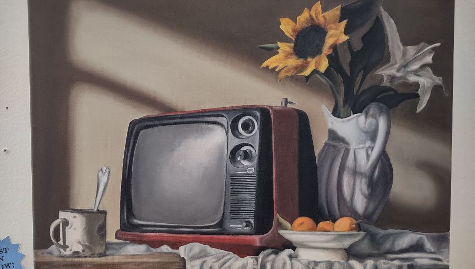 Still life painting of a vintage red television, sunflowers in a vase, fruit bowl and mug displayed at Montgomery County Community College’s Blue Bell Student Art Exhibition.