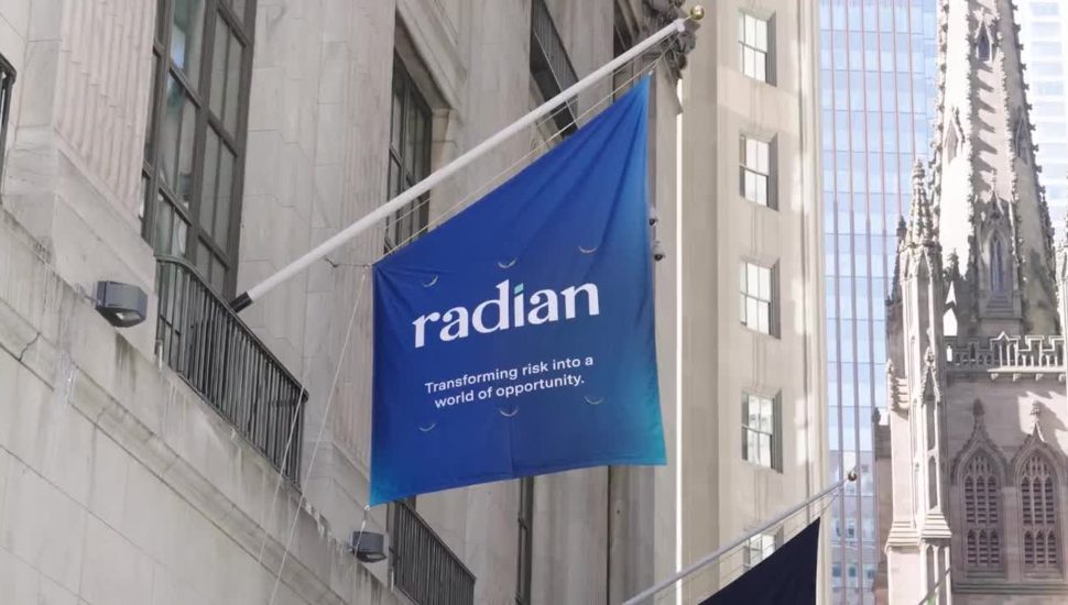 Blue flag with Radian Group sign flying outside building.