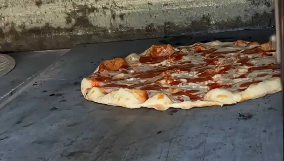 A pizza baking in the oven at Apizzeria 888 by Sebastian.