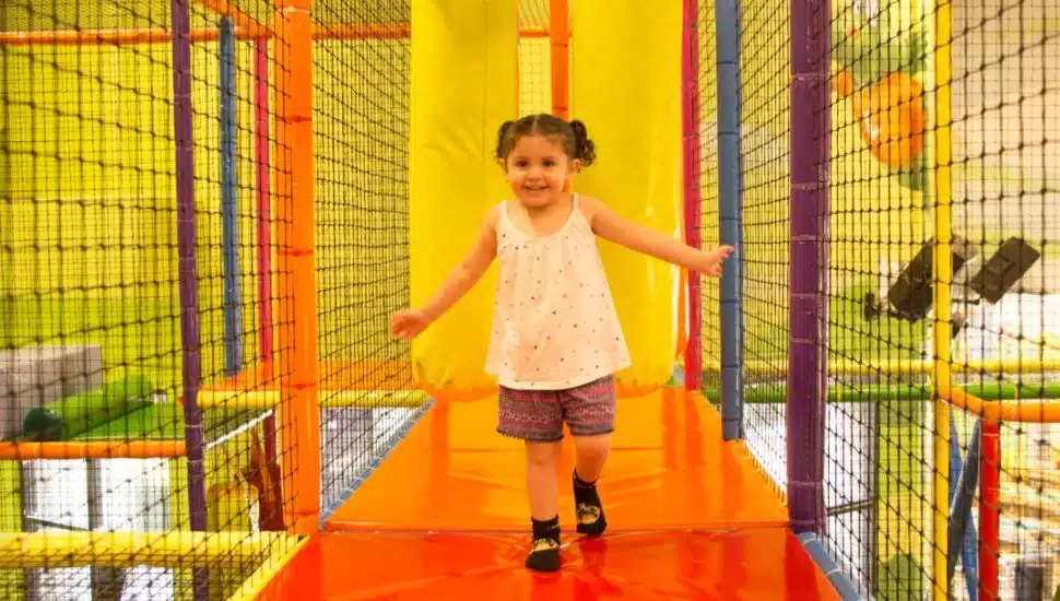 A young girl runs through the Kids Empire playroom.