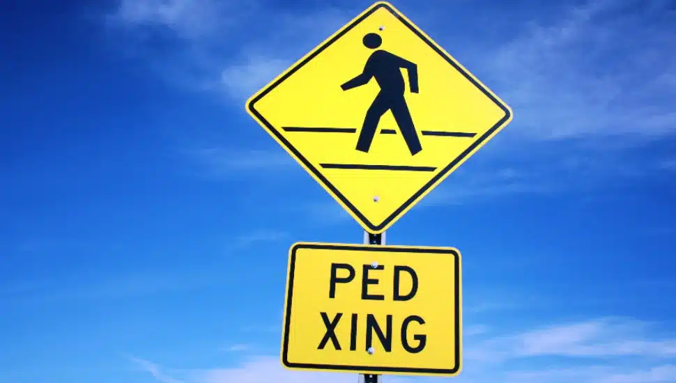A yellow 'pedestrian crossing' sign.
