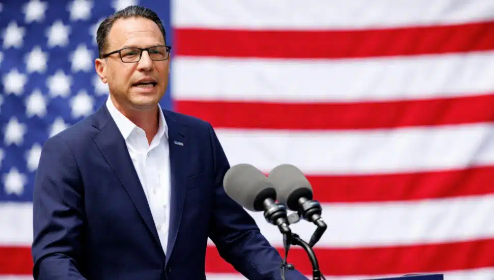 Josh Shapiro speaks form a podium in front of the American flag.