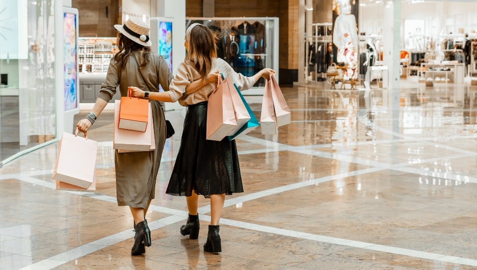 Two young women shop in a mall.