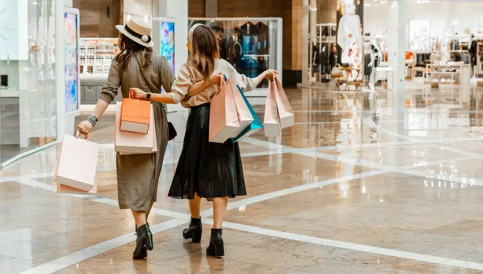 Two young women shop in a mall.