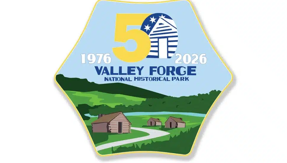 Official 50th anniversary logo for Valley Forge National Historical Park, featuring the years 1976–2026, a large "50" in gold, and an illustrated landscape of historic log cabins and rolling green hills.