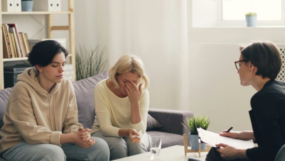 A counselor works with a family who faces addiction.