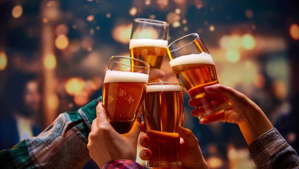 Friday mood. Old friends saying toasts and drinking beer and clinking glasses while watching match. Football fans in bar. Concept of Oktoberfest, party, celebration, taste, national traditions.