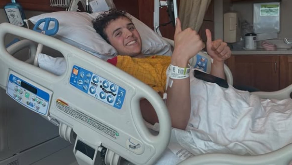 Cole Fisher offers a thumbs up from a hospital bed.