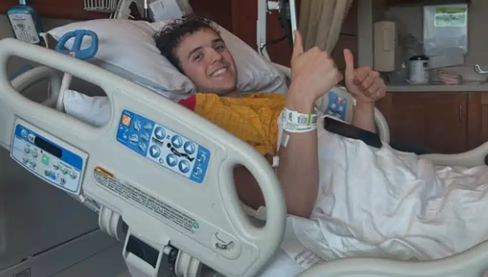 Cole Fisher offers a thumbs up from a hospital bed.