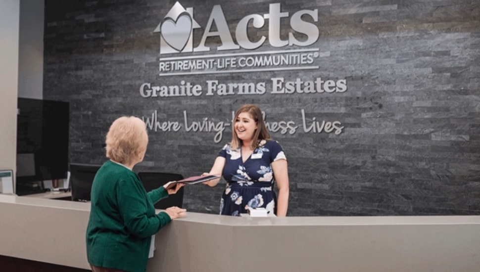 A staff member assists a resident at the front desk of Granite Farms Estates near Media, one of 28 Acts Retirement-Life Communities locations where employees will now have access to Arcadia University's workforce certificate programs.
