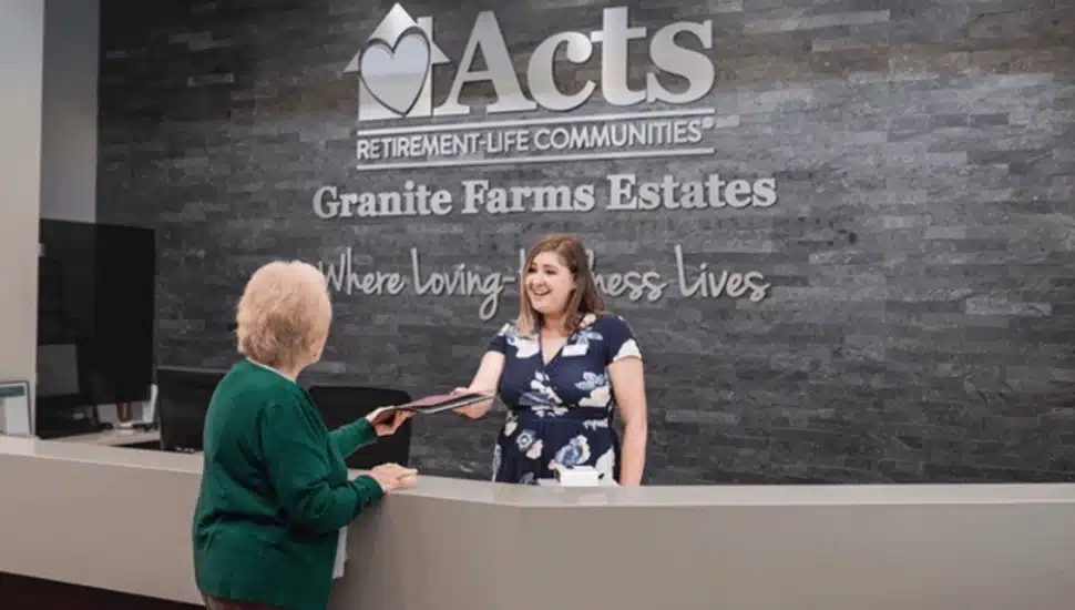 A staff member assists a resident at the front desk of Granite Farms Estates near Media, one of 28 Acts Retirement-Life Communities locations where employees will now have access to Arcadia University's workforce certificate programs.