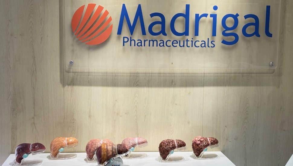 A Madrigal Pharmaceuticals sign hangs over a display of liver models.