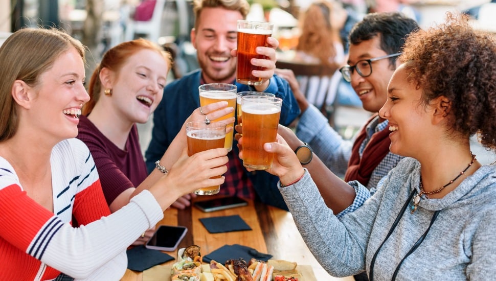 A group of friends enjoy cold beers outside.