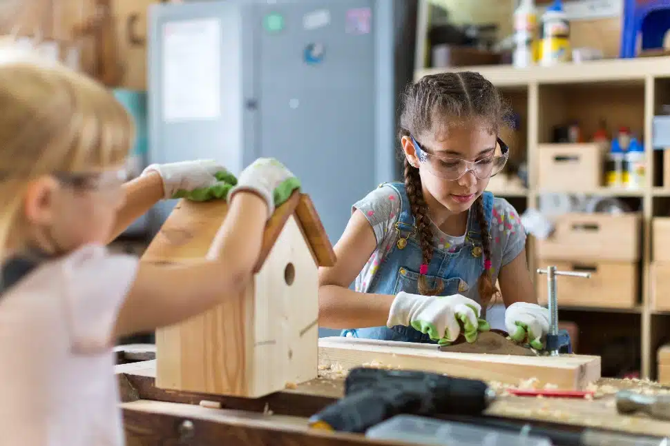 Two girls building a birdhouse